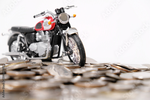 Modern classic motorcycle model on many of coins background, Finance concept.
