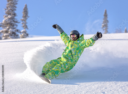 Obraz na płótnie male snowboarder curved and brakes spraying loose deep snow on the freeride slope