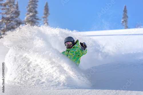 Vászonkép Extreme snowboarder has fun riding fresh powder snow off piste in white mountains