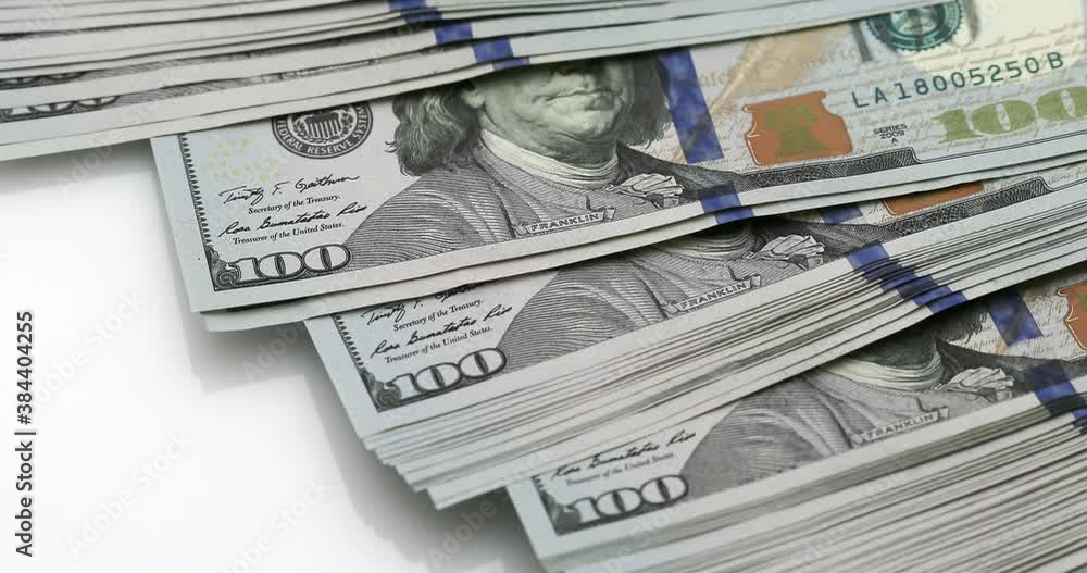 A bundle of dollars falls and crumbles on a white background A bundle of dollars falls and crumbles on a white background