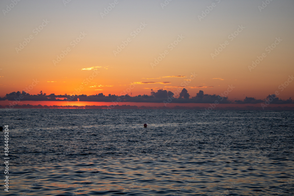 Wonderful panoramic view of the sunset over the Sochi sea with dark red clouds.