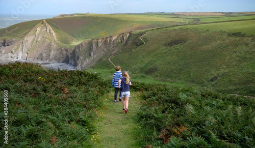 Backview of children walking on the coastal path at Hartland, North Devon.