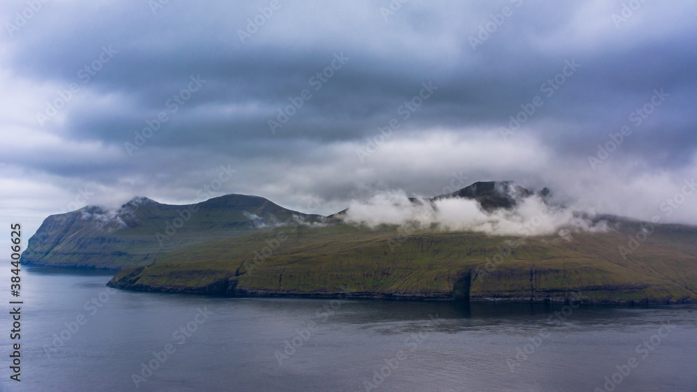 Rugged mountain landscape in Faroe Islands with Vagar Island in the background