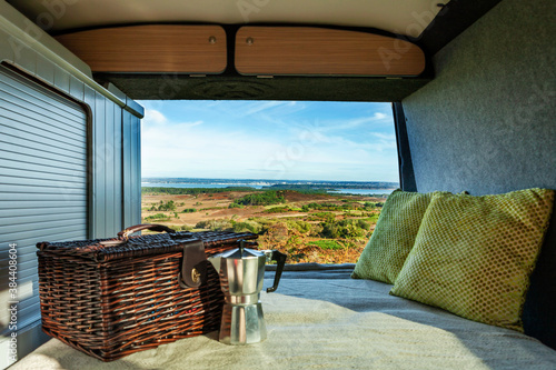 Taken from a camper van with a hamper, stove top coffee maker and cushions, overlooking the view at Poole harbour