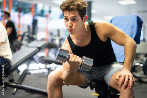 Bodybuilder using a dumbbell to work out in a gym