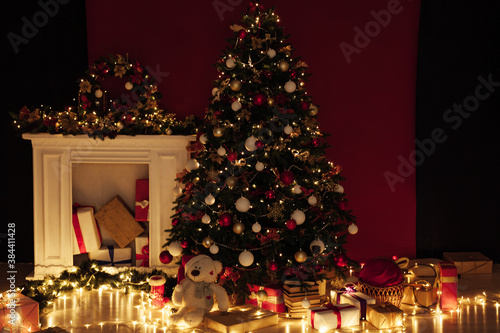 Christmas tree shines lights garlands New Year's Night Red Wall