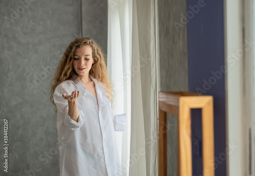 Young woman opening the curtain in the morning © surachetkhamsuk