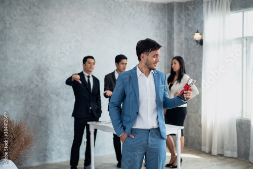 Fototapeta Businessman happy pride with win cup and business team jealous behind