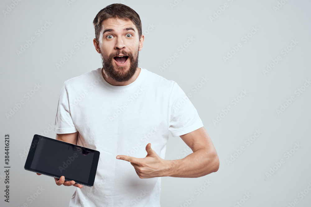 emotional man with tablet in hand touch screen new technologies light background cropped view Copy Space emotional man with tablet in hand touch screen new technologies light background cropped view Copy Space