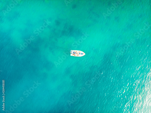 Aerial shot of a boat sailing near the island of Capo Passero. It's a small island in the southernmost Sicily, Italy