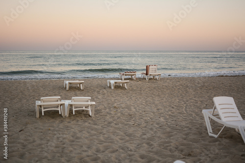Beach chairs. End of the beach season  plastic beach deck chair on an empty beach at sunset.