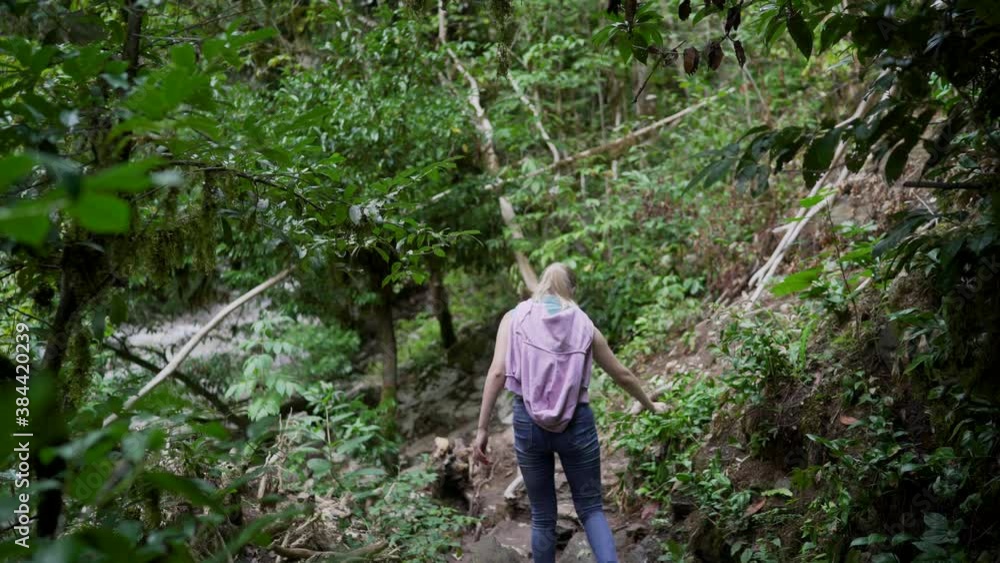 The girl is walking along a mountain path. A photographer girl travels alone. A young girl with a backpack is walking along a mountain path. The girl is walking along a mountain path. A photographer girl travels alone. A young girl with a backpack is walking along a mountain path.