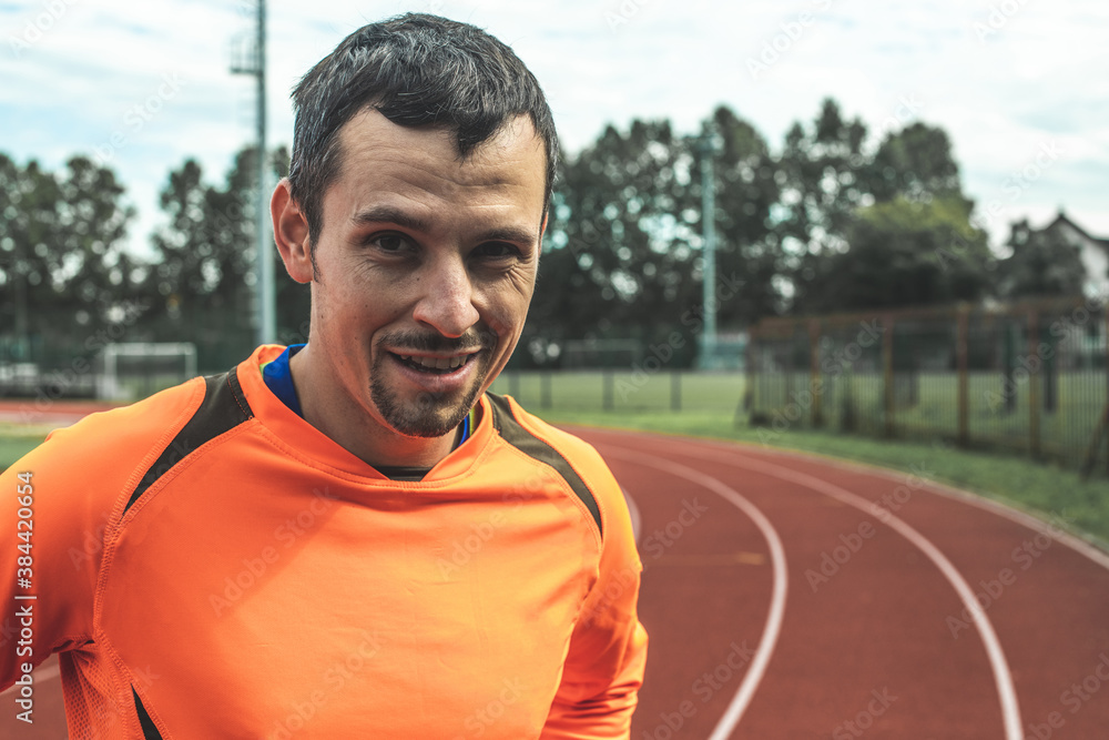 Close up portrait of a smiling Caucasian man at an athletic stadium Close up portrait of a smiling Caucasian man at an athletic stadium