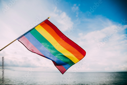 LGBT flag blown by the wind at seaside representing love and freedom. 