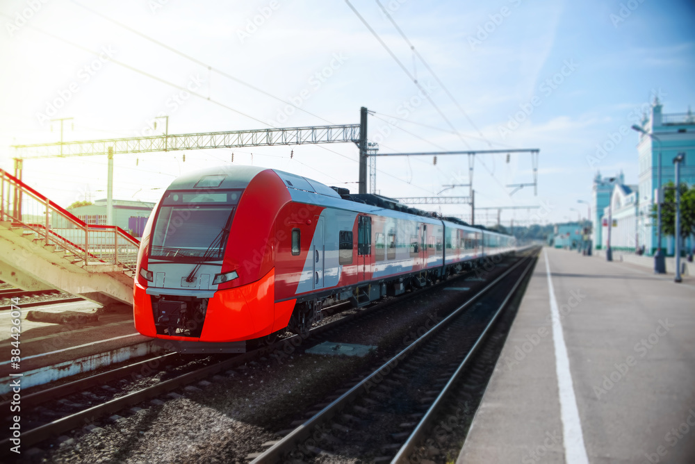 Modern high-speed train on the platform. Passenger red train at the station waiting.