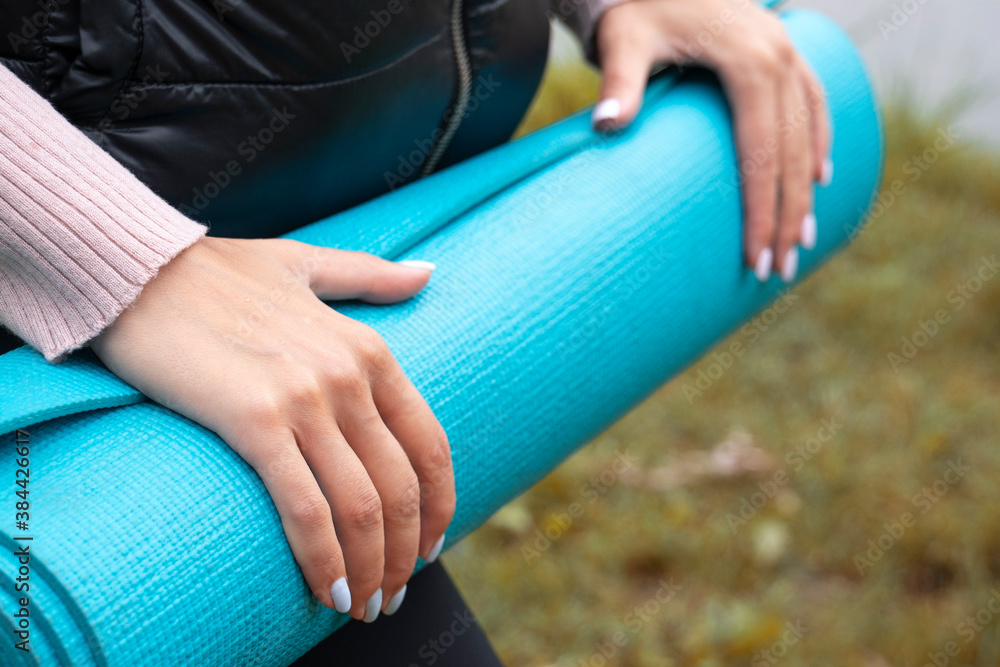 Obraz premium Women's hands hold a yoga mat. Close-up.