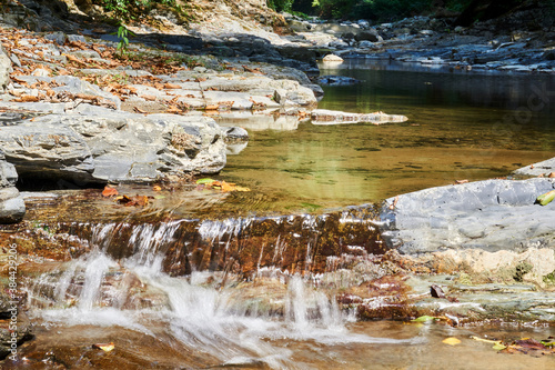 cascade of rapids on a quiet mountain river in a shady canyon photo