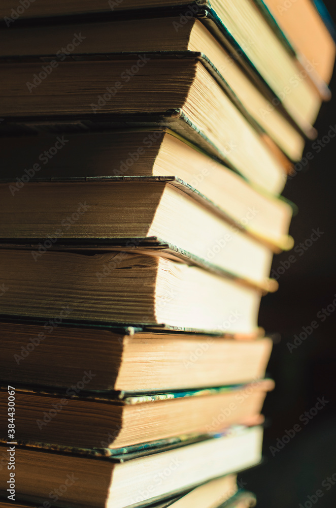 Fototapeta premium many stacks of educational books for college exams in the library on a dark background