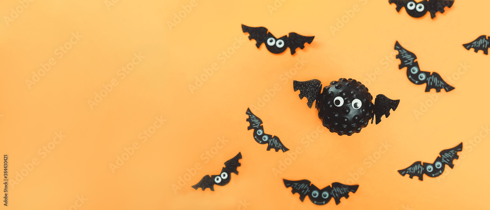 Model of Covid virus in the shape of a bat with flying bats in the background. Scariest hero in Halloween 2020. Halloween during Corona virus global pandemic concept. Wide banner. Copy space.