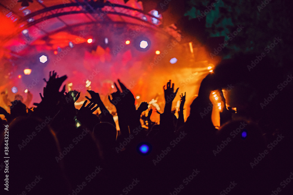 Abstract blur atmosphere: happy people enjoying outdoor music festival concert, raised up hands and clapping of pleasure, active night life concept, play of light and shadow on the stage Abstract blur atmosphere: happy people enjoying outdoor music festival concert, raised up hands and clapping of pleasure, active night life concept, play of light and shadow on the stage