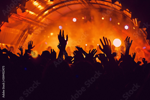 Obraz na płótnie Abstract blur atmosphere: happy people enjoying outdoor music festival concert, raised up hands and clapping of pleasure, active night life concept, play of light and shadow on the stage w salonie