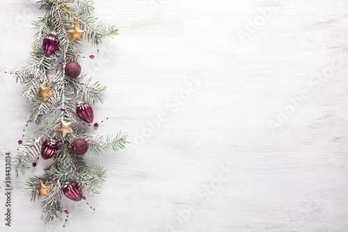 Christmas border with fir branches and  lilac baubles on white shabby wooden board with copy space for text. Flat lay.  Christmas and New Year holidays background.