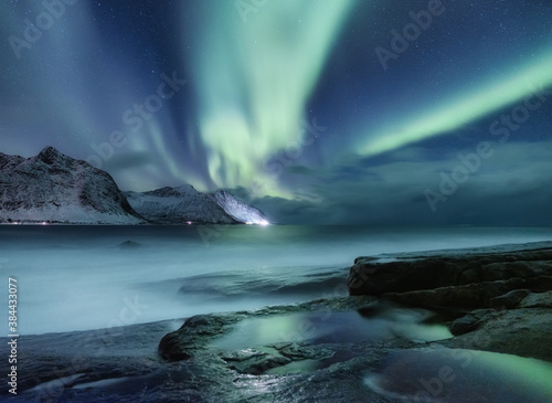 Aurora borealis on Lofoten islands, Norway. Green northern lights above mountains. Night winter landscape with aurora. Natural background in the Norway. © biletskiyevgeniy.com