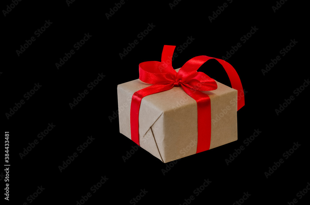 Fototapeta premium Gift box with red ribbon, copy space isolated on black background. Sales concepts, discount price, black friday, christmas gifts and shopping, greeting card for christmas, valentine's day or new year 