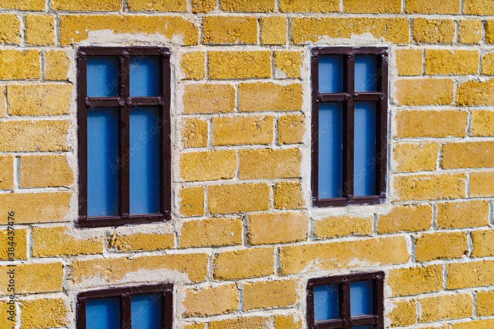 background from a miniature houses in a city park, yellow brick wall and windows background from a miniature houses in a city park, yellow brick wall and windows