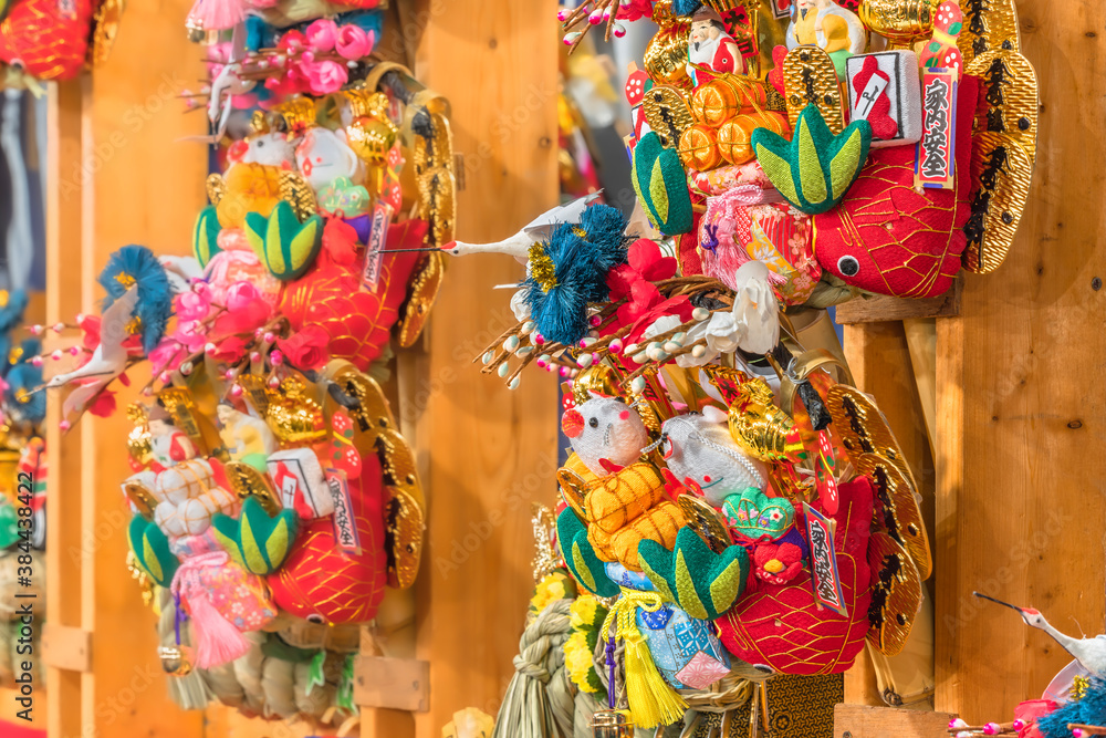 asakusa, japan - november 08 2019: Close-up on auspicious rakes or kisshō kumade made in chirimen crêpe fabric decorated with mouses, sea breams and cranes in the Tori-no-Ichi Fair of Ootori shrine.