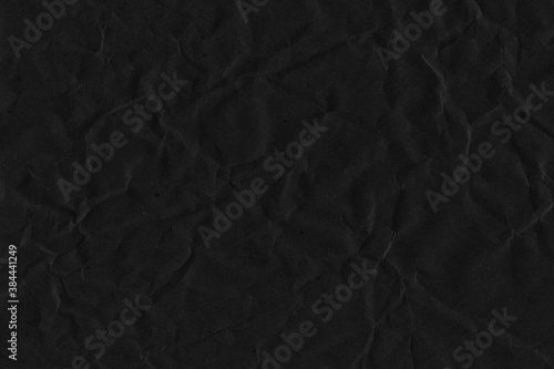 Black vintage and old looking crumpled paper background. Retro cardboard texture. Grunge paper for drawing. Ancient book page. Present wrapping. © artistmef
