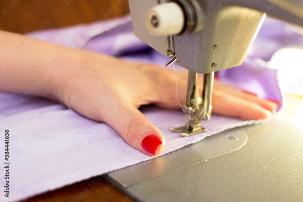 Woman taylor is working on a sewing machine