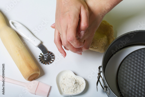 The woman is kneading the dough. Cooking tools are nearby. Levington cake, stages of preparation. photo