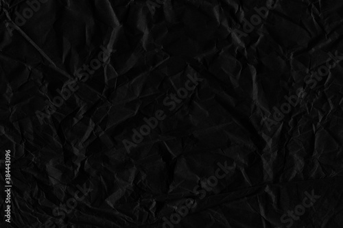Black vintage and old looking crumpled paper background. Retro cardboard texture. Grunge paper for drawing. Ancient book page. Present wrapping.