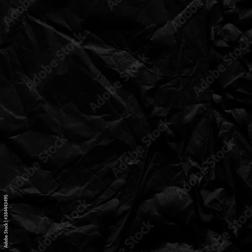 Black vintage and old looking crumpled paper background. Retro cardboard texture. Grunge paper for drawing. Ancient book page. Present wrapping.