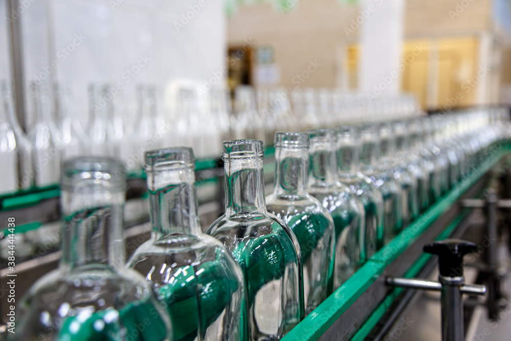 Factory for the production of alcoholic beverages. Bottles of vodka on the conveyor. Factory for the production of alcoholic beverages. Bottles of vodka on the conveyor.