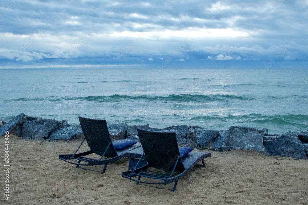 Two chaise lounges on sandy beach along Lake Huron coastline in Michigan at morning Two chaise lounges on sandy beach along Lake Huron coastline in Michigan at morning