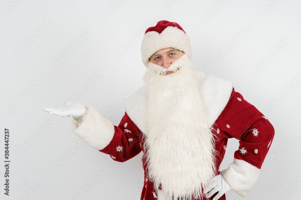 Santa Claus shows a pointing gesture, raising the palm of his hand to the top. Isolated background. Santa Claus shows a pointing gesture, raising the palm of his hand to the top. Isolated background.