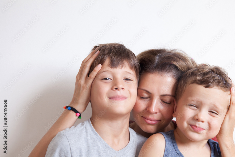 Portrait of happy mother with cute kids boy on a light background. Happy family concept. Portrait of happy mother with cute kids boy on a light background. Happy family concept.