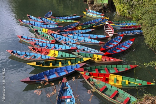 Group of multi colored Fishing Boats on freshwater Phewa or Fewa Lake in Pokhara, Nepal