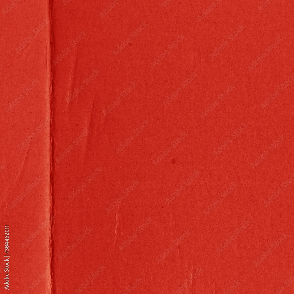 Fototapeta premium A red vintage rough sheet of carton. Recycled environmentally friendly cardboard paper texture. Simple and bright minimalist papercraft background.