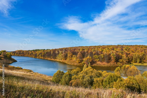 autumn landscape of lake and orange forest on the slope. panoramic view of the forest river on a sunny autumn day