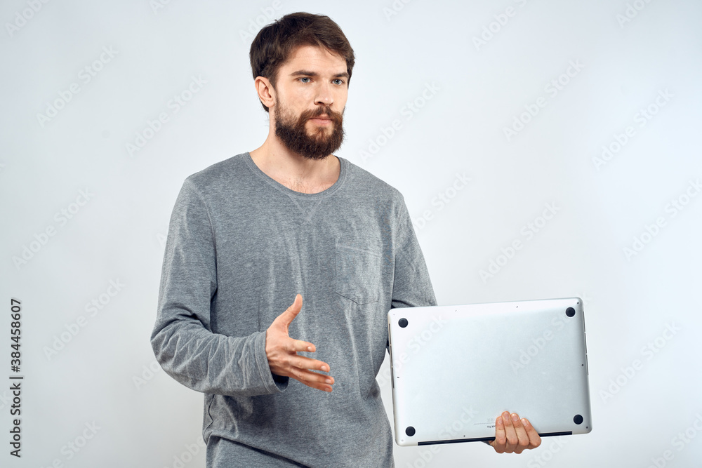 Emotional man holding a laptop success modern style work light background Emotional man holding a laptop success modern style work light background