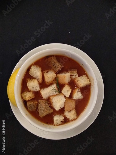 Soup from Turkish cuisine, crunchy bread and lemon with greens
