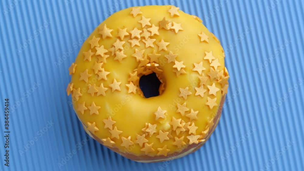 Bright and colorful sprinkled donut close-up shot spinning on a color background. Seamless looping. Bright and colorful sprinkled donut close-up shot spinning on a color background. Seamless looping.