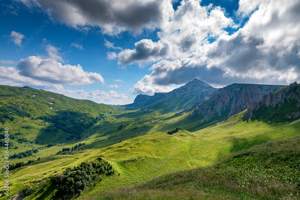 Beatiful mountain meadow with endless blue sky and clouds