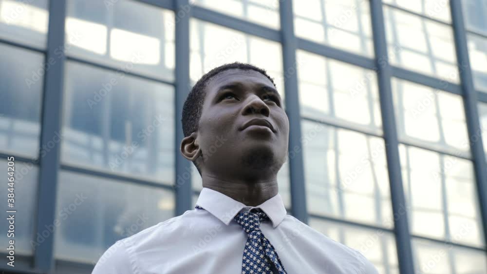 win, success - black businessman raising his head looking up and smiling win, success - black businessman raising his head looking up and smiling