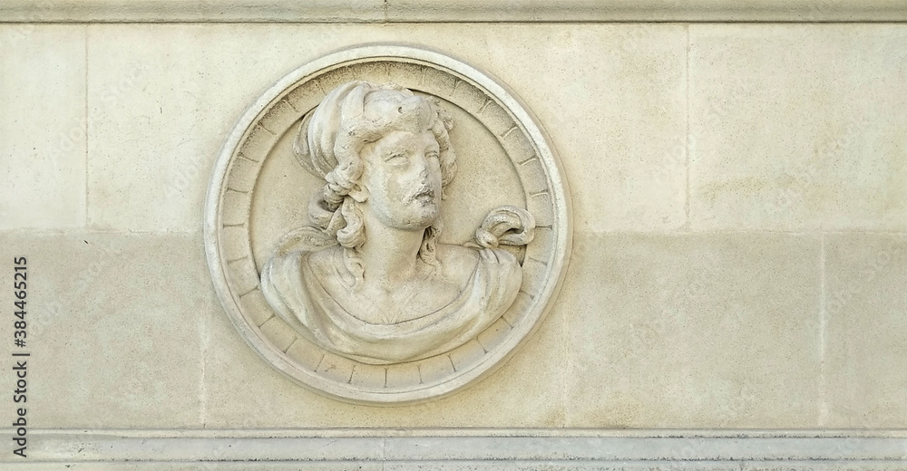 Naklejka premium Ornament in white stone of a broken ancient relief on a wall which represents a profile portrait of a woman with frames with free space in the sides
