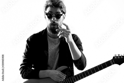 Male musician with guitar music rock star light background