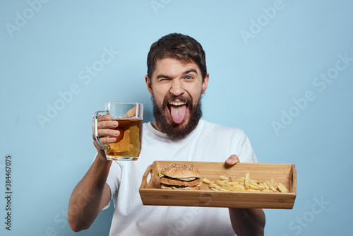 Cheerful man mug of beer fast food diet food lifestyle blue background alcohol